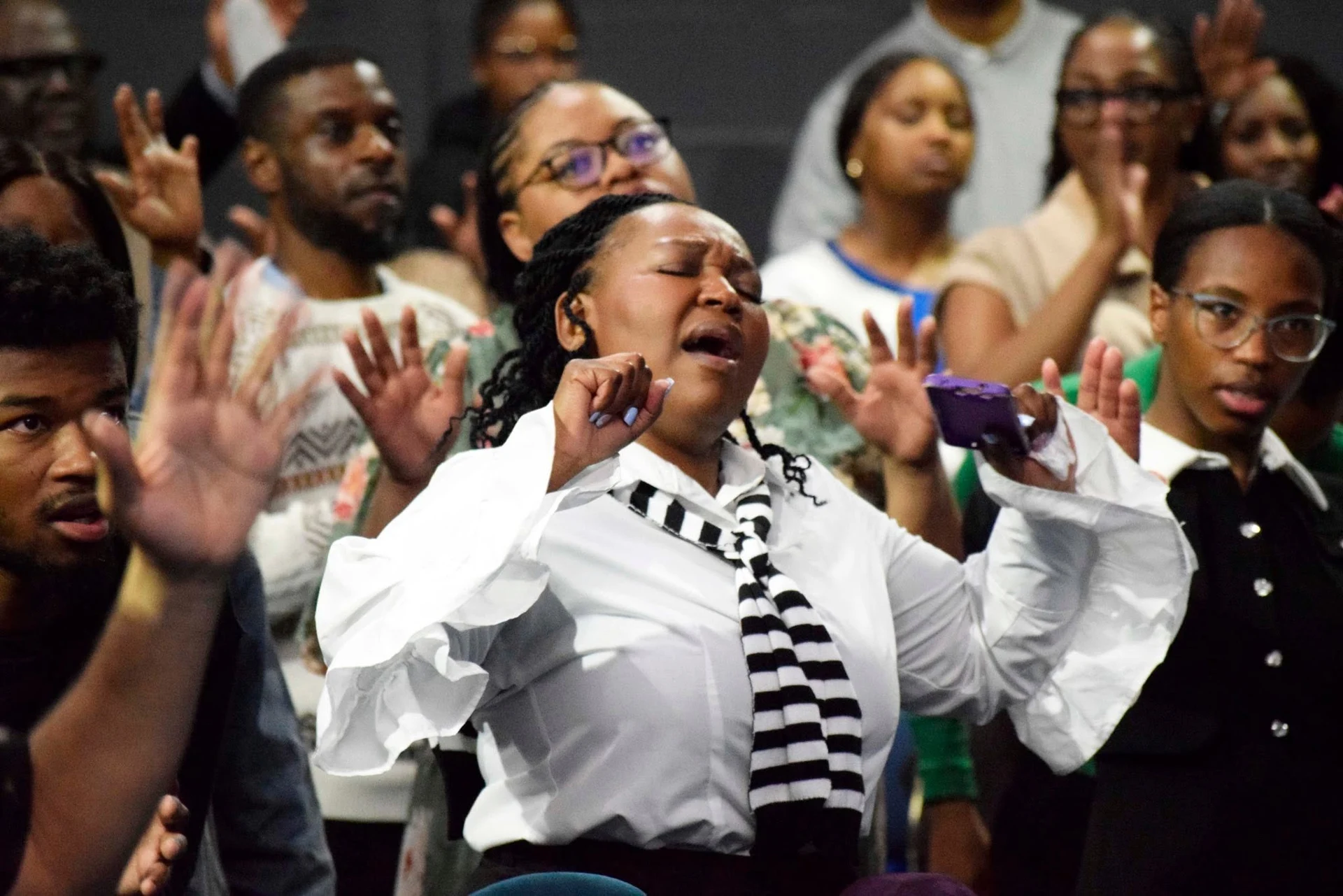 Henosis congregation worshipping with raised hands
